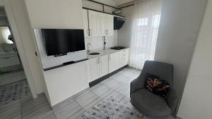 a kitchen with a chair and a television in a room at Köşk Rezidans Apart in Aksaray
