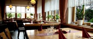 a restaurant with tables and chairs and windows at Haus am Mühlberg in Modautal
