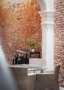a brick walled patio with a table and chairs at Aayu Melayu - George Town Penang in George Town