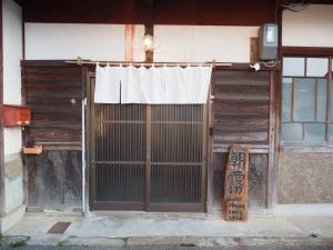 an entrance to a building with a gate and a curtain at The Asagiri Guest House in Tanabe
