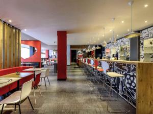 a restaurant with a bar with tables and chairs at ibis Nürnberg City am Plärrer in Nuremberg