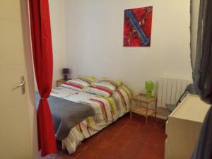 a bedroom with a bed with a red curtain at Appartements Cote pont Vieux-Self Check-In in Carcassonne