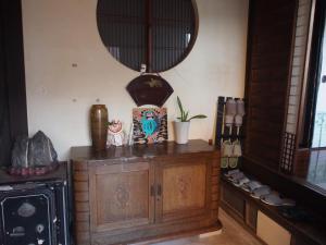 a room with a wooden cabinet and a mirror at The Asagiri Guest House in Tanabe