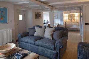 a living room with a blue couch and a table at Rose Cottage in Wadebridge