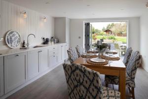 a kitchen with a wooden table with chairs and a dining room at Rose Cottage in Wadebridge