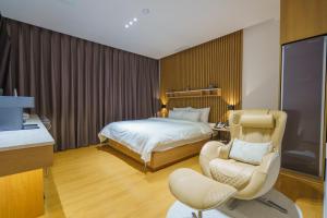 a hotel room with a bed and a chair at Hotel Hariu in Gwangju +95 photos