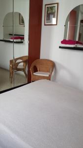 a bedroom with a bed and a chair and mirrors at Room Sol Vecindario Gran Canaria Free parking in Vecindario