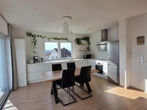 a kitchen with a wooden table and black chairs at Apartment Ilmtalblick in Pfaffenhofen an der Ilm +2 photos
