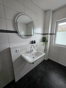 a white bathroom with a sink and a mirror at Apartment Ilmtalblick in Pfaffenhofen an der Ilm