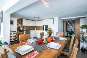 a dining room and kitchen with a wooden table and chairs at Panoramic View Cottage House - Private Wellness Retreat in Hočko Pohorje +37 photos