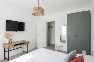 a bedroom with a bed and a desk and a tv at MoKi by Garda FeWo in Moniga +30 photos