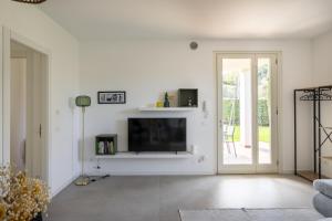 a living room with a flat screen tv on a white wall at MoKi by Garda FeWo in Moniga