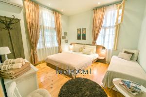 a bedroom with two beds and a table and a window at TOMOVI HOME - Three bedrooms City center in Plovdiv