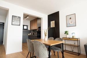 a dining room and kitchen with a table and chairs at ONL Apartments in Dunajská Streda