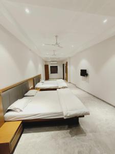 a room with three beds in it with a tv at LL Palace in Hinganghāt +3 photos