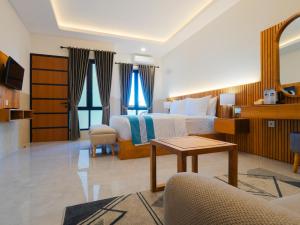 a hotel room with a bed and a table at Wana Kubu Homestay in Kuta