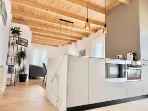 a kitchen with white cabinets and a counter at Señorial Panorámico by apartamentoscatedralcamino in Burgos