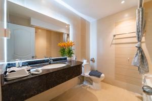 a bathroom with a sink and a toilet and a mirror at Golden Suites Saigon in Ho Chi Minh City +117 photos
