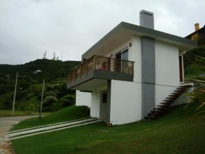 a white building with a balcony on the side of it at Casa Morrinhos in Garopaba
