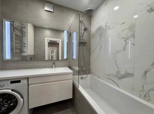 a bathroom with a sink and a washing machine at Ривер люкс Днепр in Dnipro