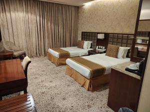 a hotel room with two beds and a table at Rabigh Park Hotel in Rabigh +26 photos