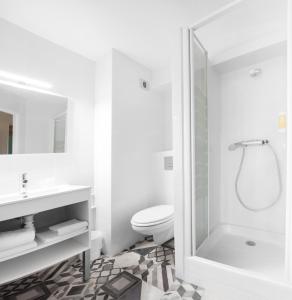 a white bathroom with a shower and a toilet at The Originals Access, Hôtel Clermont-Ferrand Nord in Châteaugay