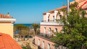 a pink building with a view of the ocean at Hotel de la plage in Banyuls-sur-Mer