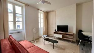 a living room with a red couch and a flat screen tv at Nevers à la Porte de Paris in Nevers