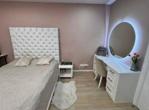 a bedroom with a bed and a vanity and a mirror at Ривер люкс Днепр in Dnipro