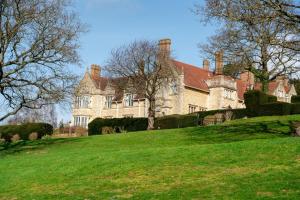 a large house on top of a grassy hill at Rutland Hall Hotel & Spa in Oakham