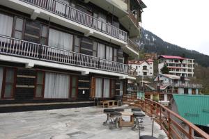 a balcony of a building with stools on it at The Himalayan Drift Cottages in Vashisht