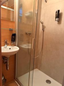 a shower with a glass door next to a sink at Motel M in Malacky +44 photos