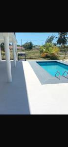 a swimming pool with a table and a chair next to it at Korah house in Saint Philip +14 photos