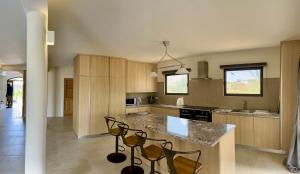 a kitchen with a counter and chairs in it at Korah house in Saint Philip