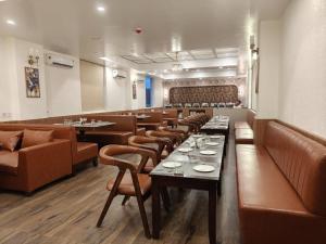 a restaurant with a row of tables and chairs at Hotel Grand Maspel in Dimapur