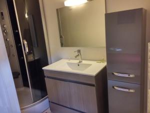 La salle de bains est pourvue d'un lavabo et d'un miroir. dans l'établissement Appartements Cote pont Vieux-Self Check-In, à Carcassonne