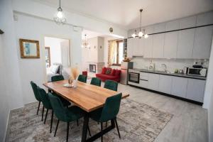 a kitchen and dining room with a wooden table and green chairs at Gravia's Villa in Graviá