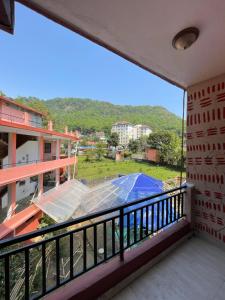 a balcony with a view of a blue umbrella at Hotel Everest Lake View in Pokhara +12 photos