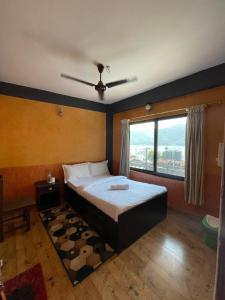a bedroom with a bed with a ceiling fan at Hotel Everest Lake View in Pokhara