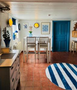 a kitchen with a table and chairs and a blue door at Villa Park lgh in Borgholm
