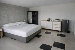 a bedroom with a large white bed and a dresser at Sea Sky Dreams in Kuta Lombok