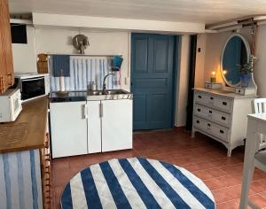 a kitchen with white cabinets and a blue door at Villa Park lgh in Borgholm +9 photos