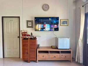 a room with a table and a clock on the wall at Bann Kieng Kiri Khaoyai บ้านเคียงคีรี เขาใหญ่ in Mu Si