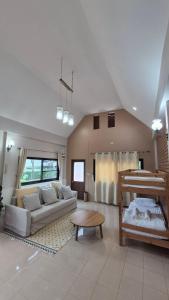 a living room with a couch and a table at Bann Kieng Kiri Khaoyai บ้านเคียงคีรี เขาใหญ่ in Mu Si