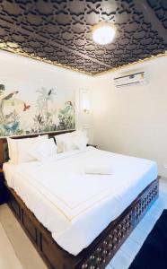 a large bed in a room with a ceiling at The S - Luxurious Stays in Mahabaleshwar
