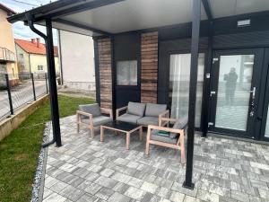a patio with two chairs and a couch and a table at Tiny homes ŠMARNA in Ljubljana