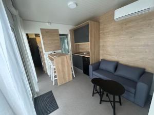 a living room with a couch and a table and a kitchen at Tiny homes ŠMARNA in Ljubljana +9 photos