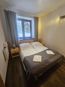 a bedroom with a bed with two towels on it at Przystanek Dolina Kościeliska in Kościelisko