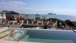 a swimming pool with a view of the ocean at Villa Kinnari in Ko Phangan