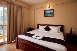 a hotel room with a large bed and a window at Coffee Bean Inn in Bangalore